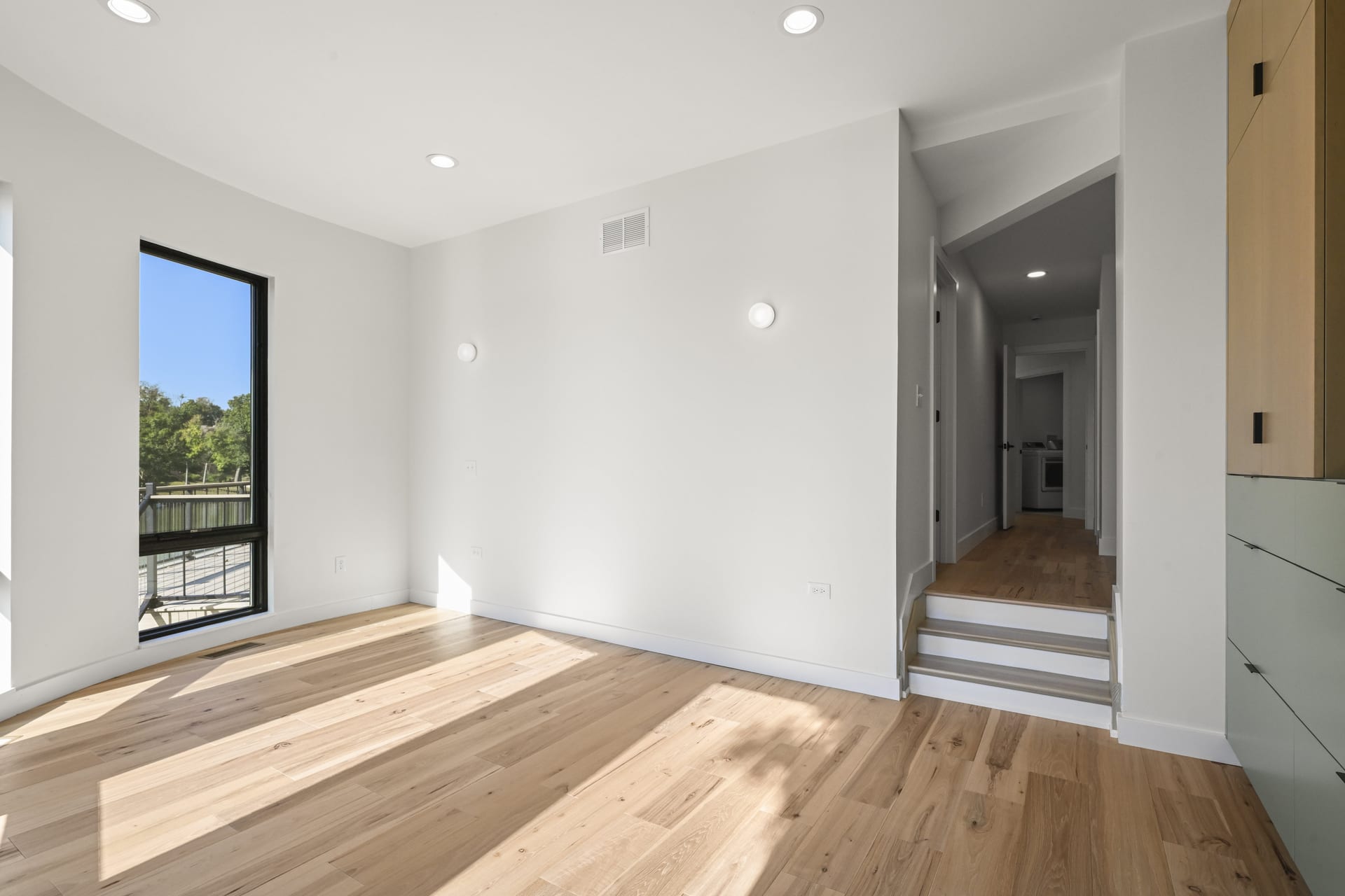 Staircase and hallway with hardwood in custom home