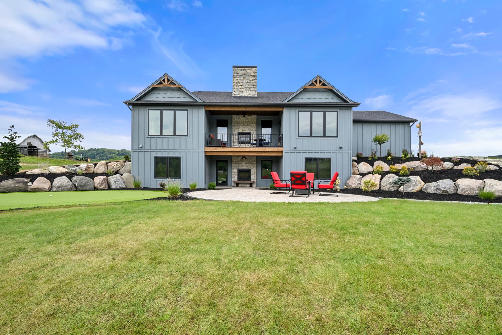 Covered rear porch with outdoor furniture in custom Indiana home